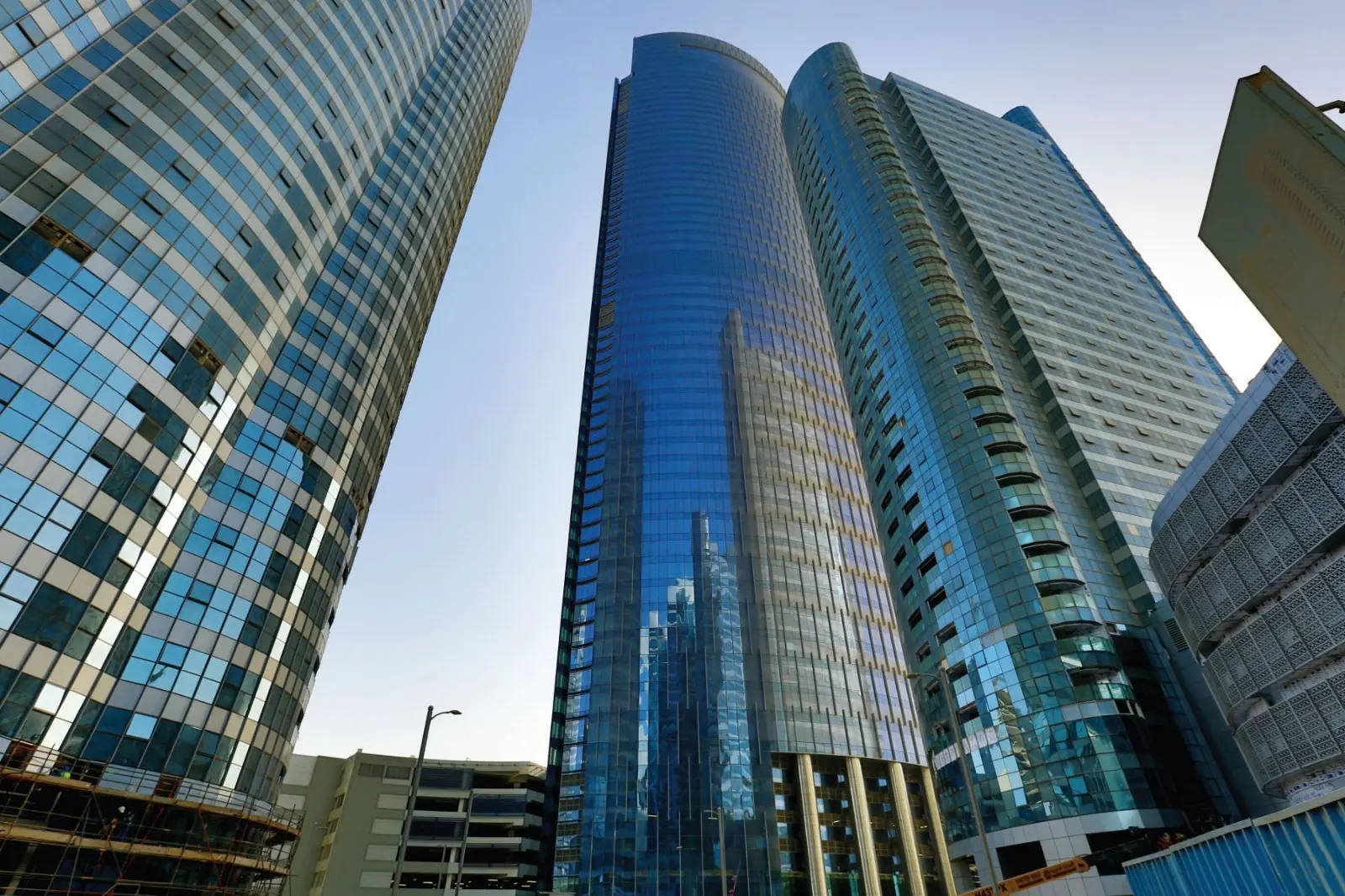 Contemporary commercial glass skyscraper Addax Office Tower in Al Reem Island Abu Dhabi overlooking the coastal canal skyline.